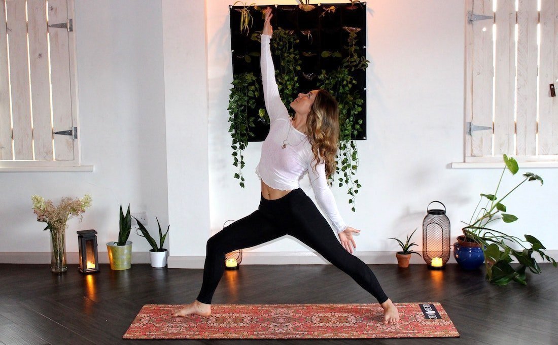 Une femme pratiquant le yoga dans son espace dédié.