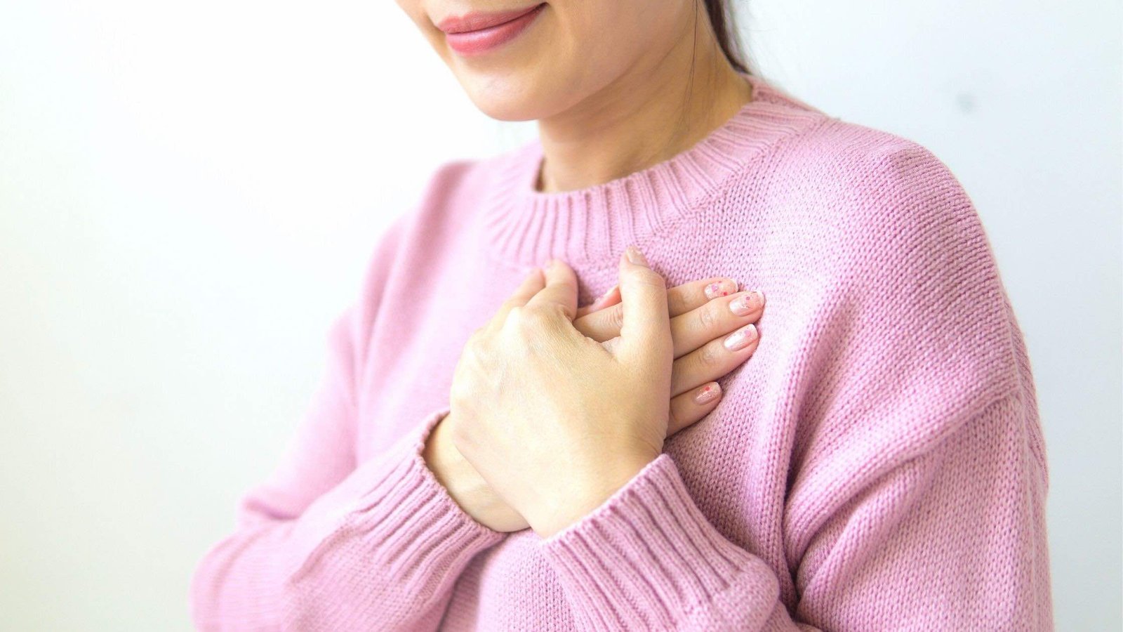 Femme mettant la main sur son coeur et pratiquant la cohérence cardiaque